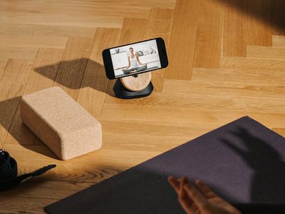 Roll of a grey fitness mat on wooden floor